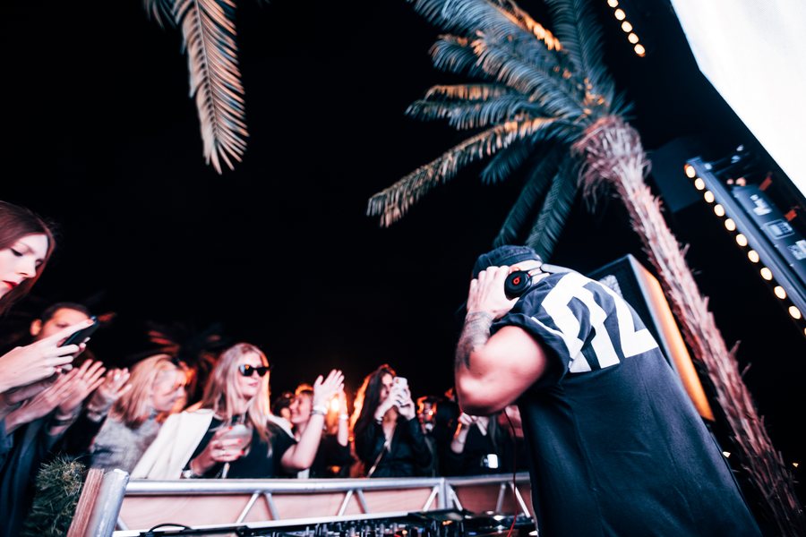L.B.ONE listening through his headphones during a club set